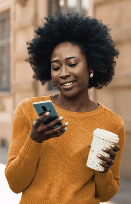 A woman checking her phone while on a coffee run