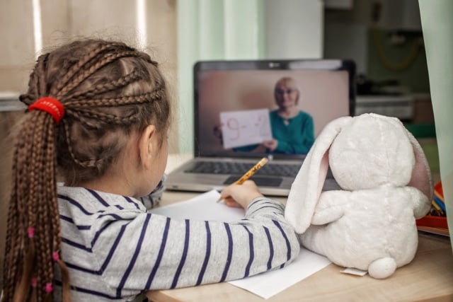 schoolgirl studying online lesson at home, social distance during quarantine, online education