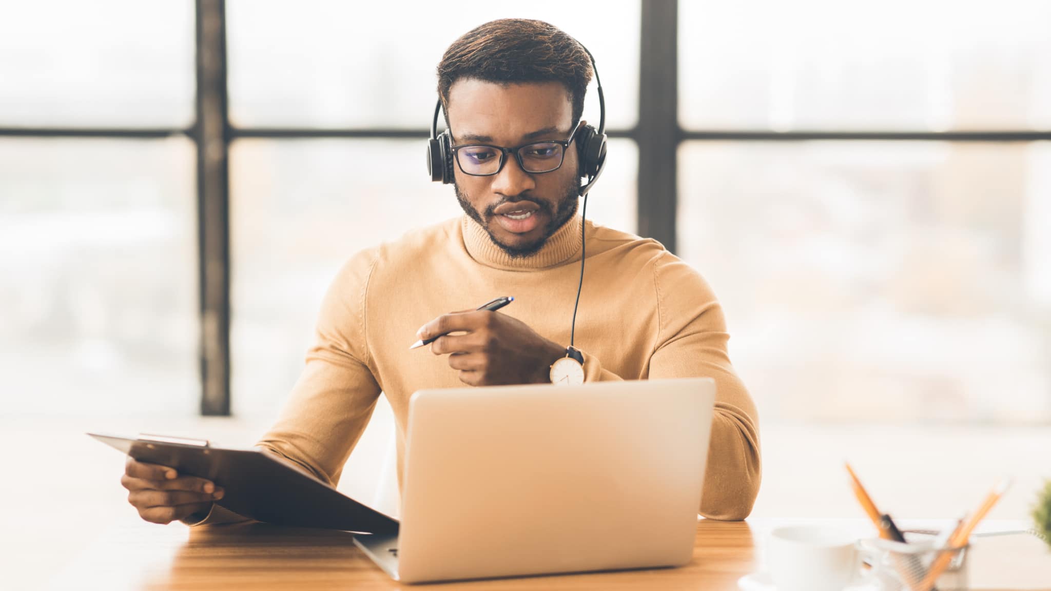 remote working male contact centre agent sat at a desk having a video call with a customer