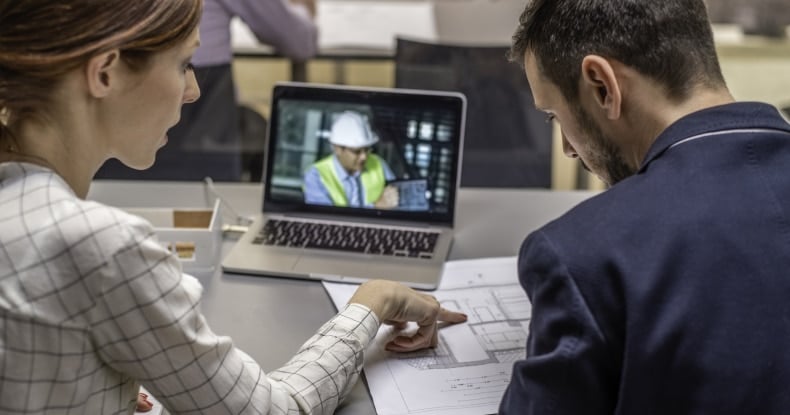 Two architects having video conference to collaborate with a colleague.