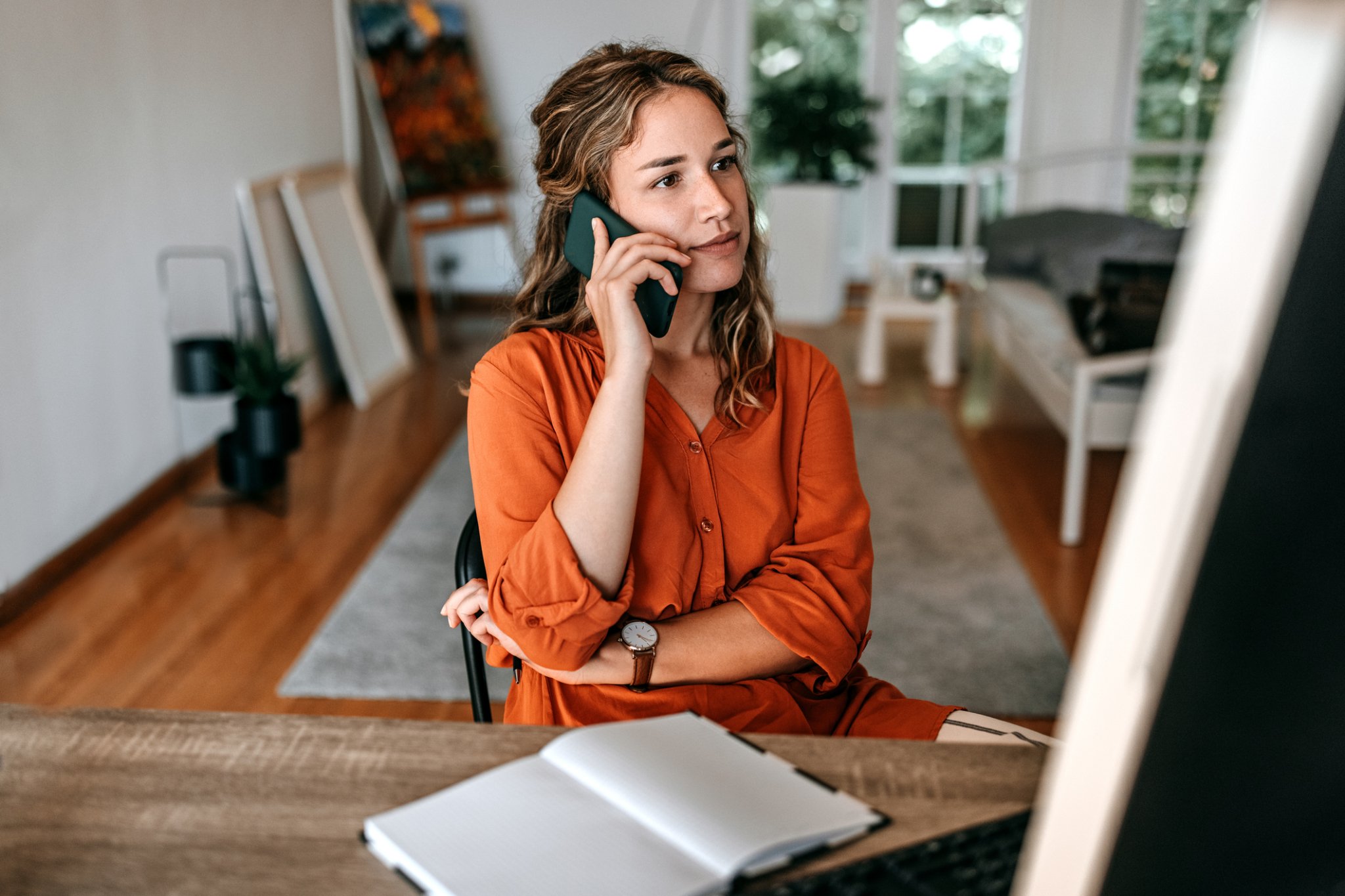 Young woman talking on smart phone at home office. This type of phone will help businesses prepare for the PSTN switch-off