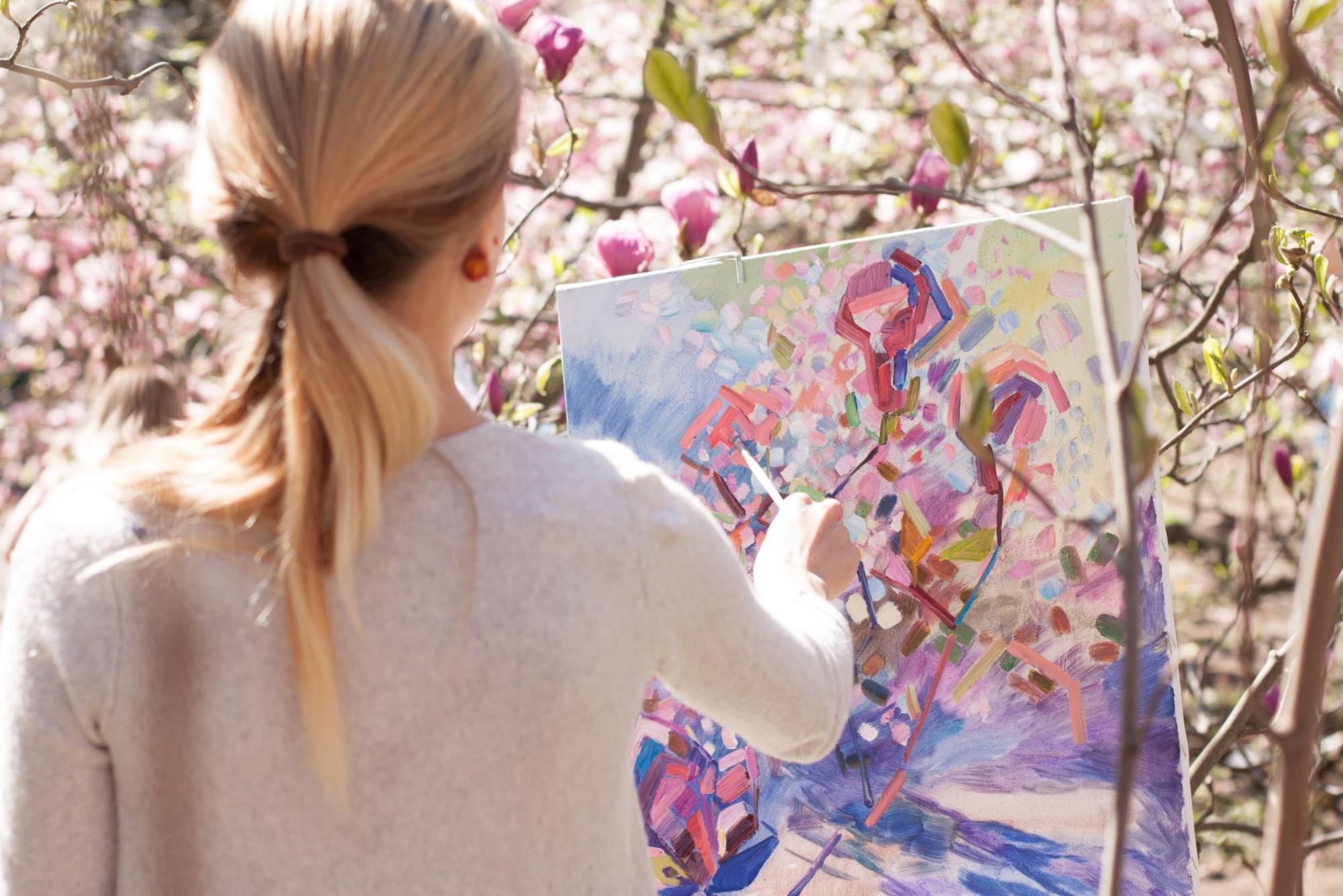 A painter working on a painting outdoors before selling it online