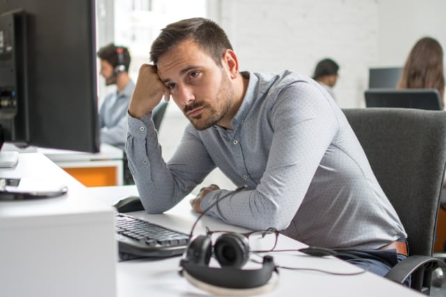 Worried beard man looking at computer screen in office-625