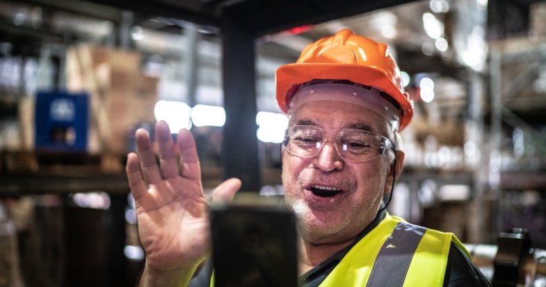 employee doing a video call on mobile phone at warehouse industry