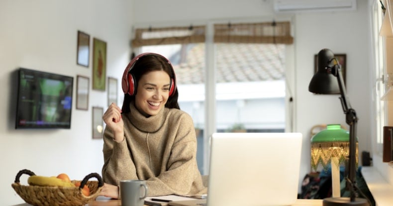 happy young woman working from home on a laptop