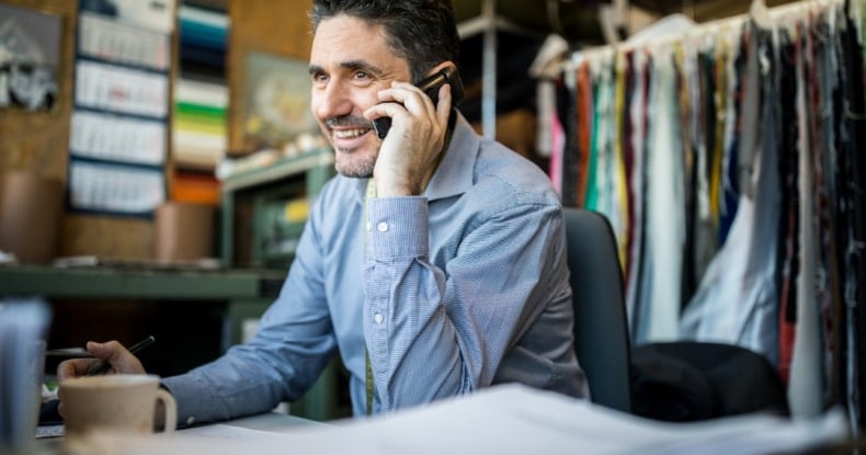 man in a clothes shop speaking on a mobile phone