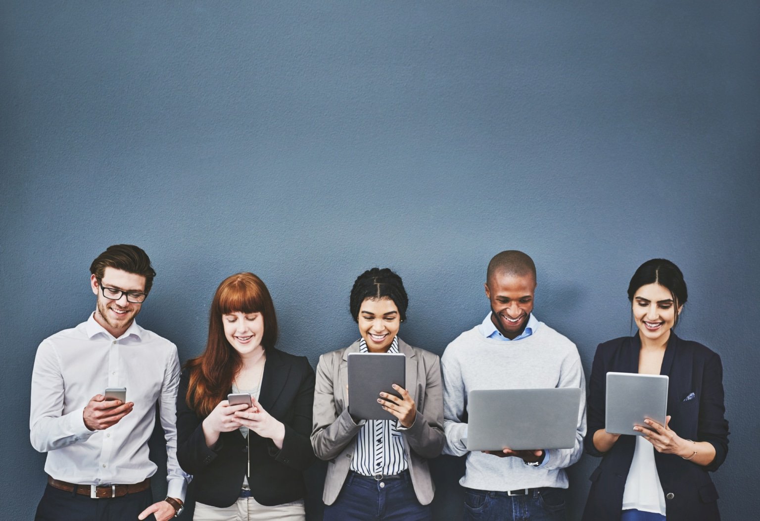 A group of people each holding a phone, tablet or laptop