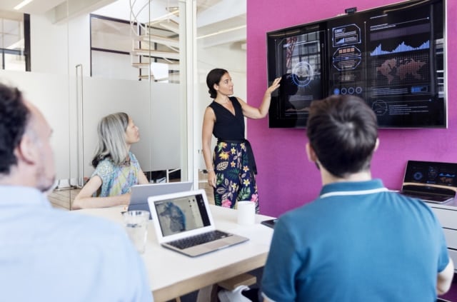 Businesswoman using graphs on screen in business meeting | RingCentral UK