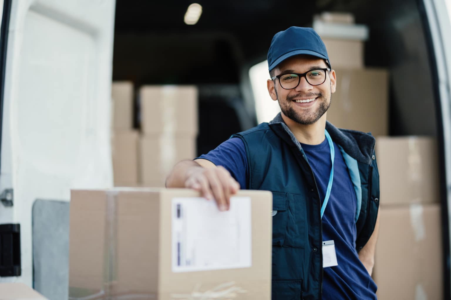 happy worker unloading boxes from a delivery van