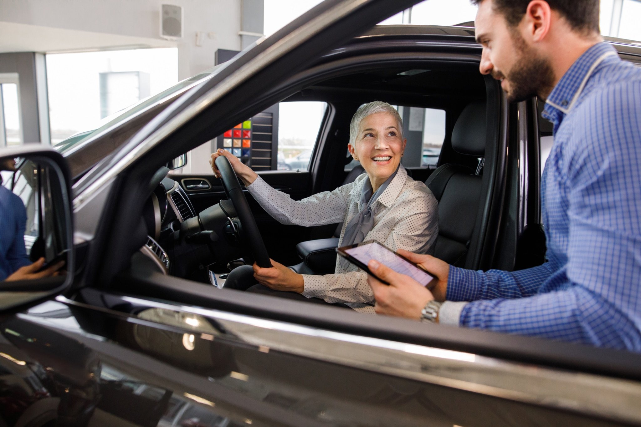 Salesperson showing vehicle to potential customer