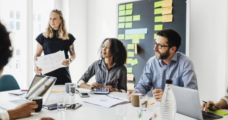 Group Of People Sitting At Conference Table During Office Presentation-886