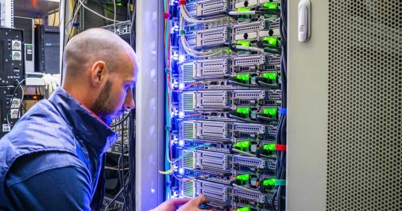 A man works with telecommunications. The technician switches the Internet cable of the powerful routers. A specialist connects the wires in the server room of the data center.-337