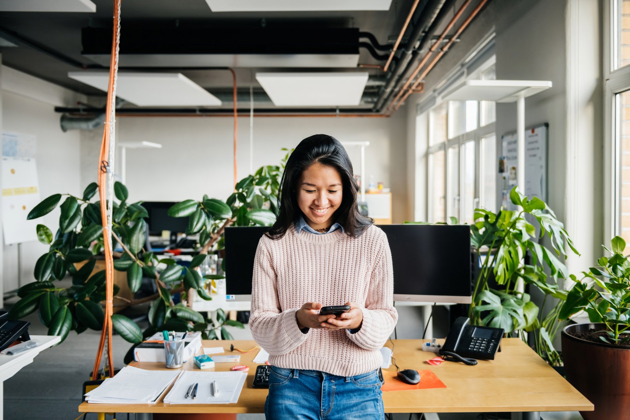 Young Office Employee Using Smartphone At Desk-447