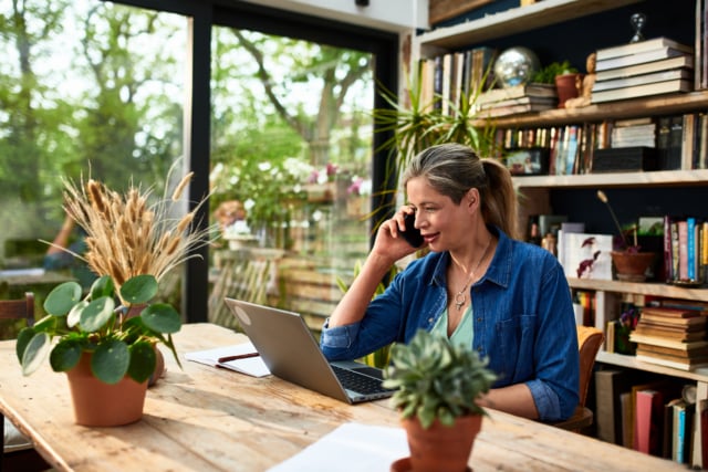 Businesswoman using mobile phone in front of laptop-429