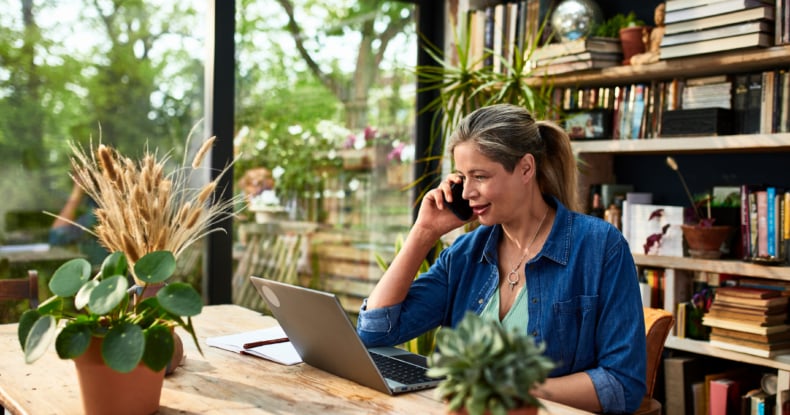 Businesswoman using mobile phone in front of laptop-429