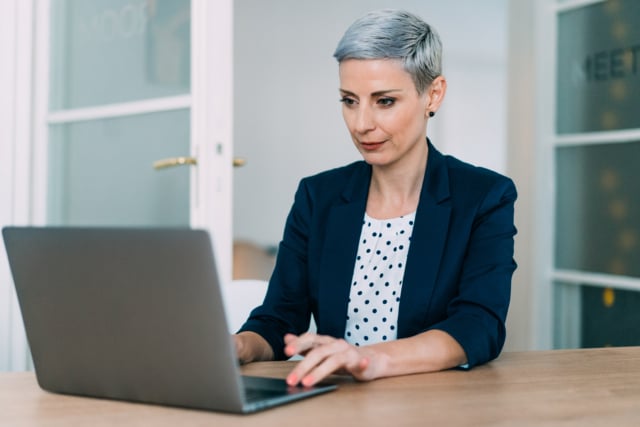 A woman bidding farewell to her colleagues virtually