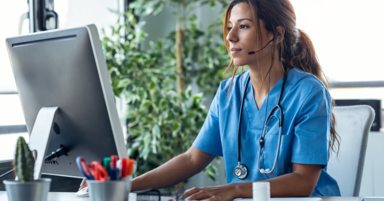 Female doctor talking with earphone while explaining medical treatment to patient through a video call with computer in the consultation.-351