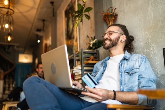 Happy young man doing some online shopping-654