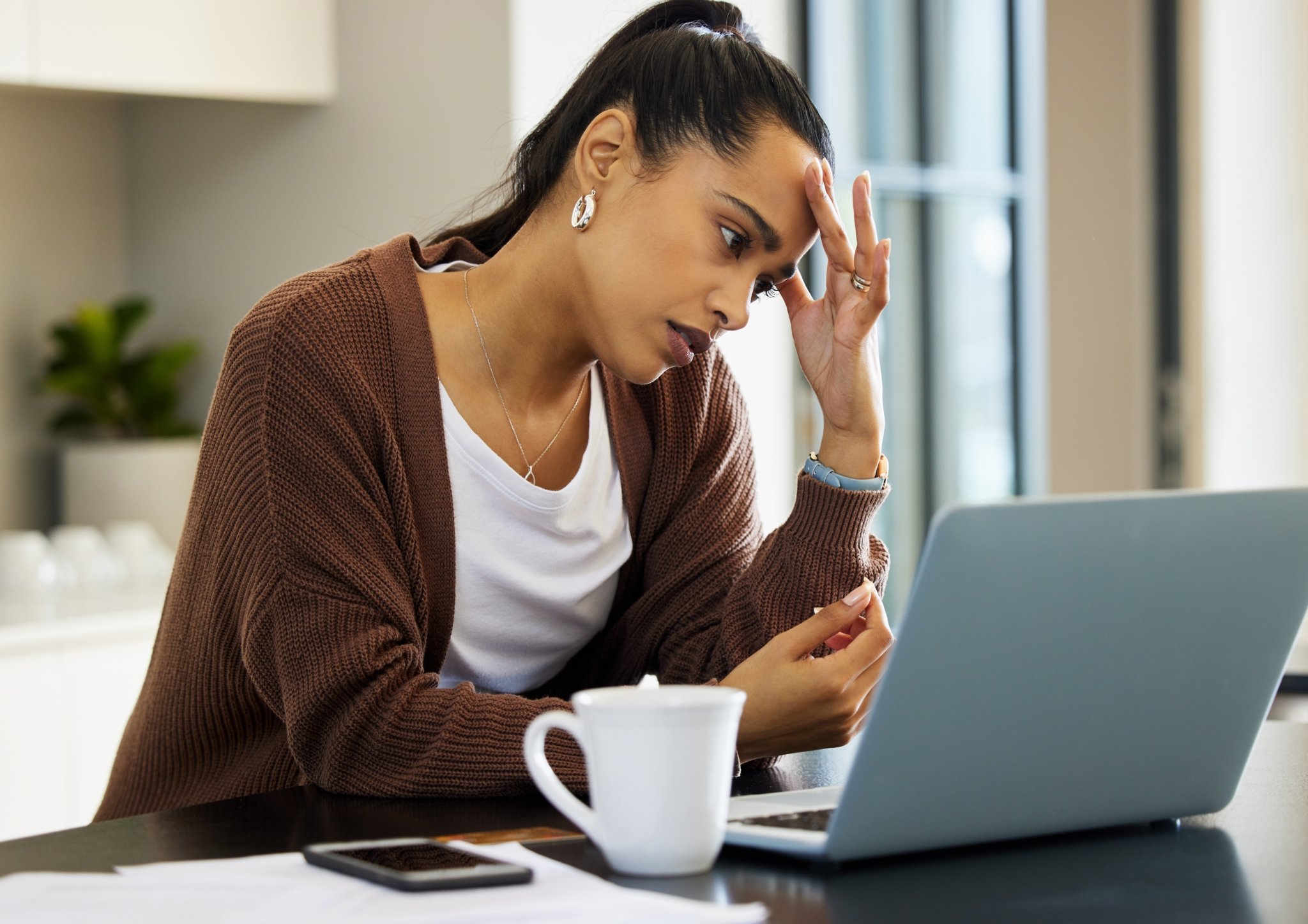 Shot of a young woman looking stressed while working on her laptop at home-760