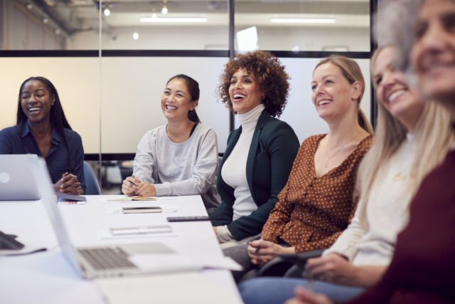 Line Of Businesswomen In Modern Office Listening To Presentation By Colleague-647