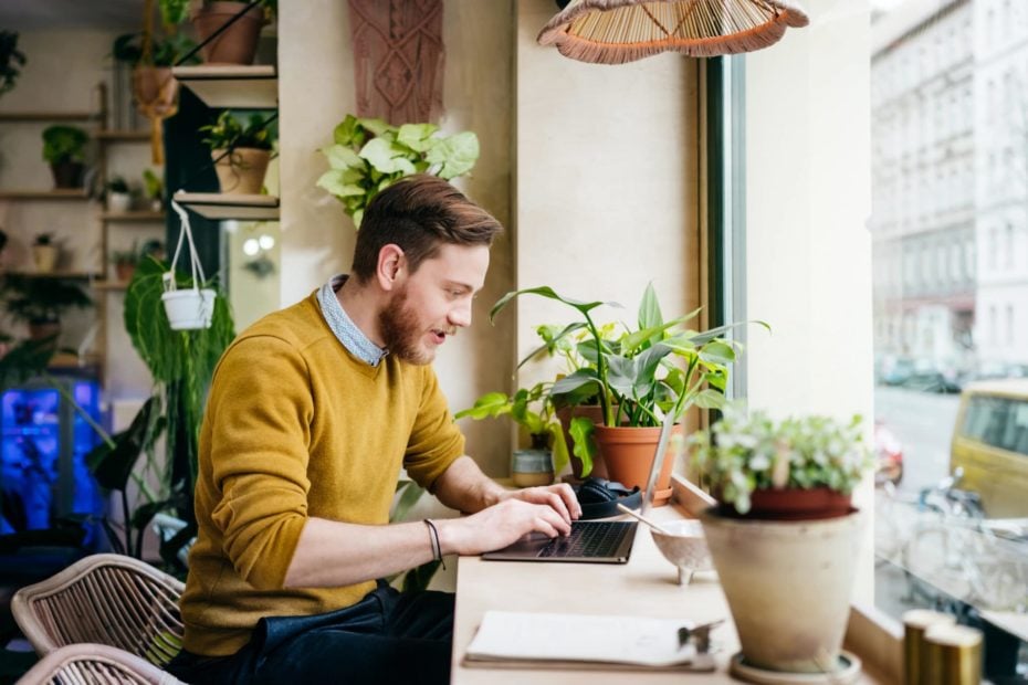 A man writing sales email subject lines on a laptop