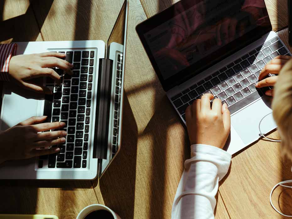 Two professionals using their laptops