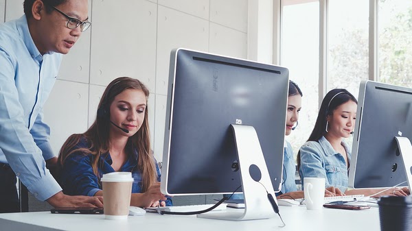 Group of people working at desktop computers.