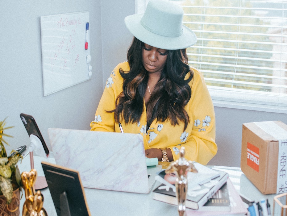 Black woman working from home in yellow top