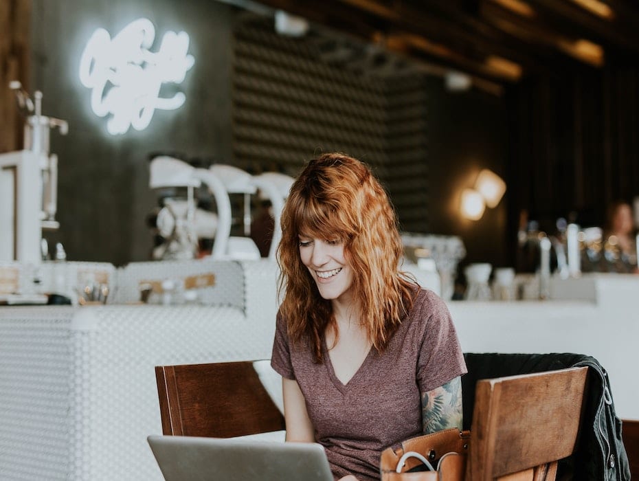 Woman working on laptop in coffee shop