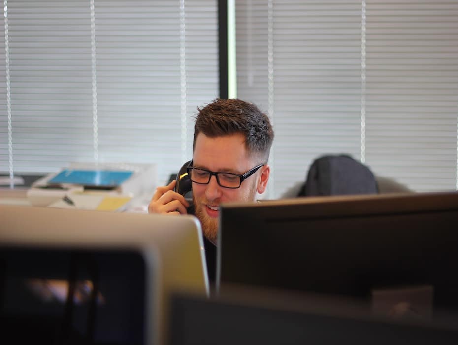 Man on phone in front of computer screens