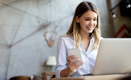 Business woman answering the phone with a smile, receiving good news