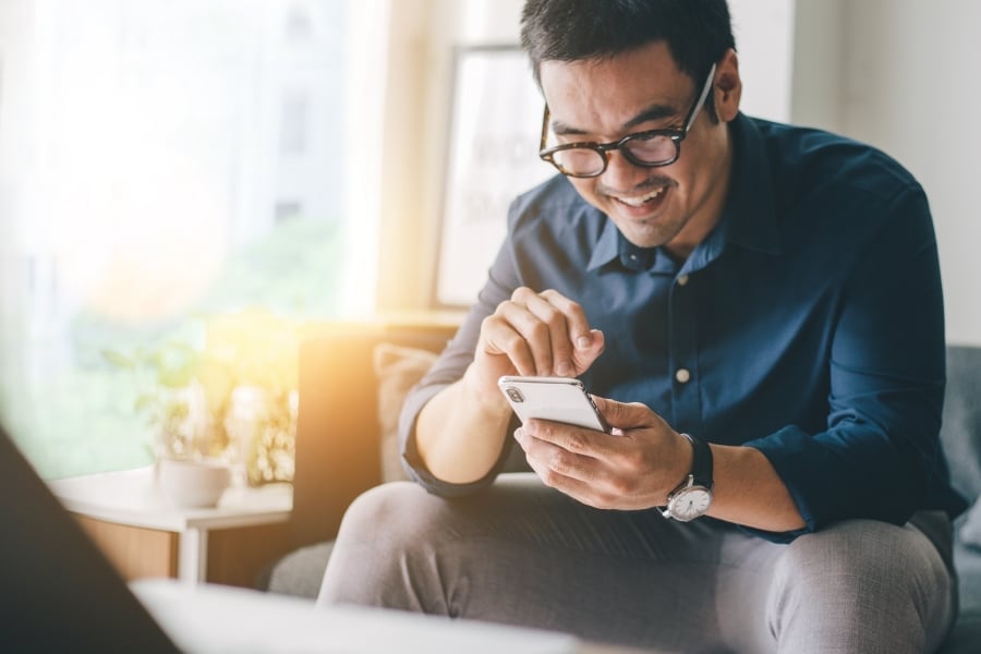 Using cell phone.hand holding texting message on screen mobile chatting friend ,search internet information sitting on sofa in office.technology device contact communication connecting people concept