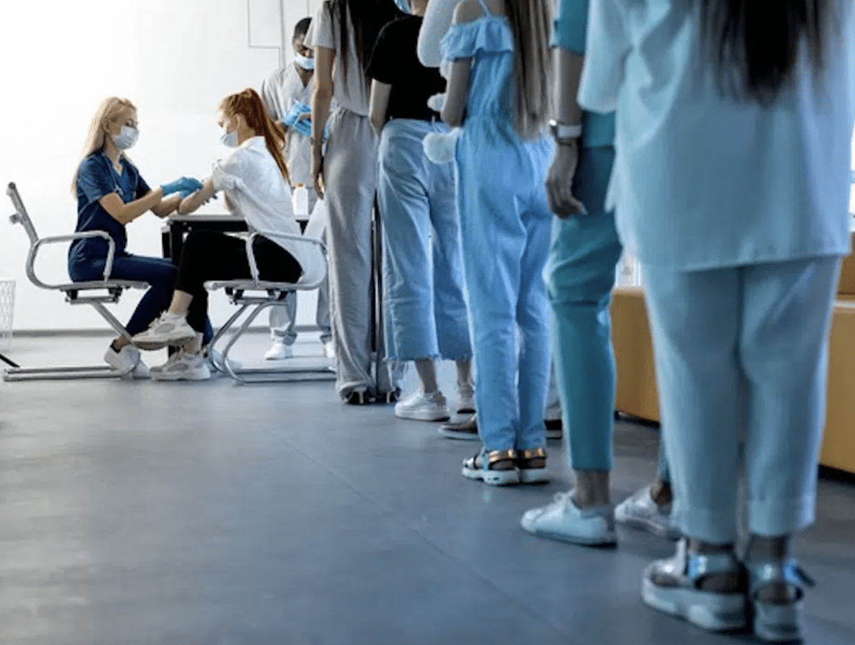 Female research scientist holding a clinical trial with a line of participants