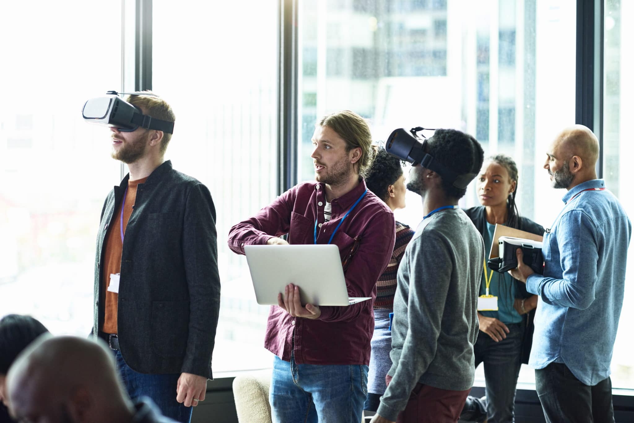 People using VR glasses and laptop in modern office