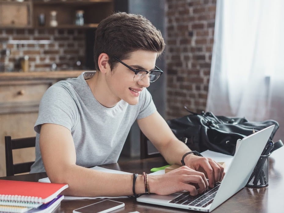 Student typing on a laptop in a hybrid learning environment