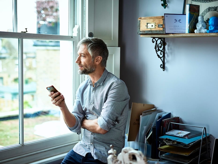 Disengaged customer using phone and looking through window