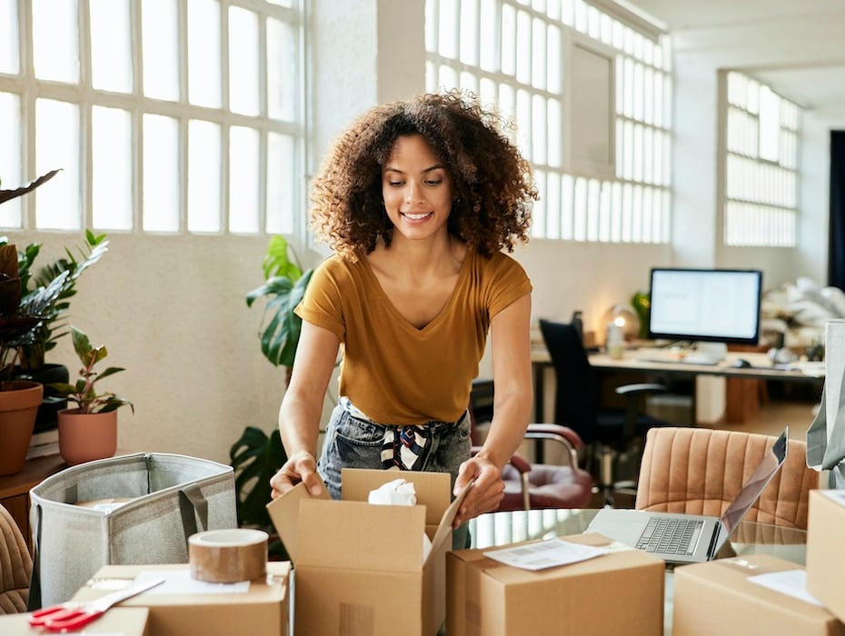 Confident business owner packing boxes at table getting ready for the future of small businesses