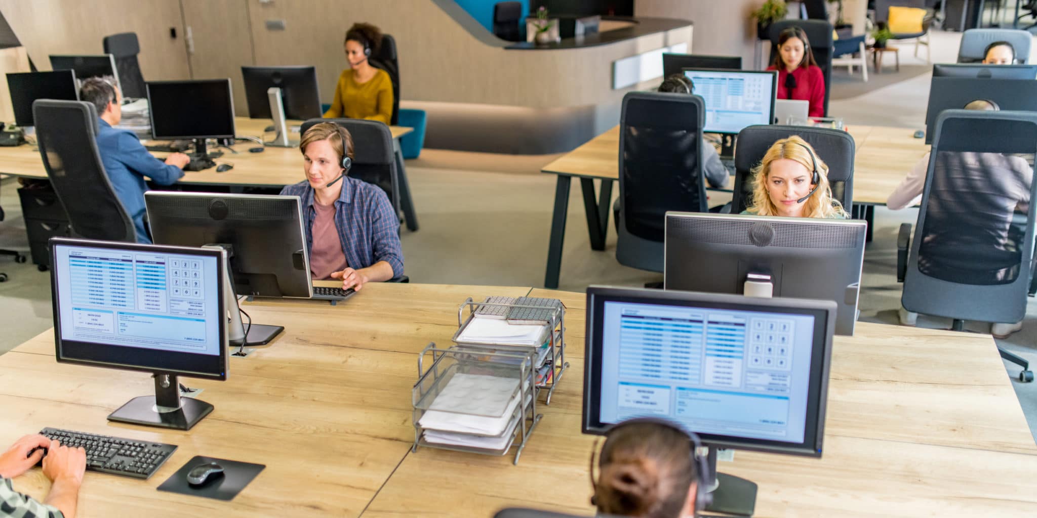 Customer service representatives working at their desktop computers in call center