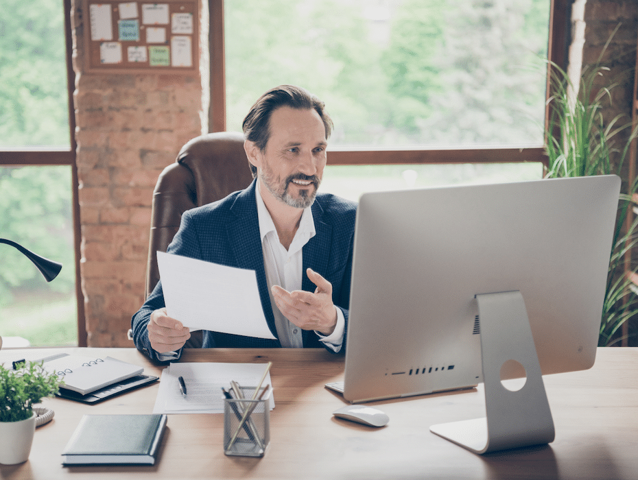 Health plan payer employee sitting at a desk attending a remote conference with a secure communications platform