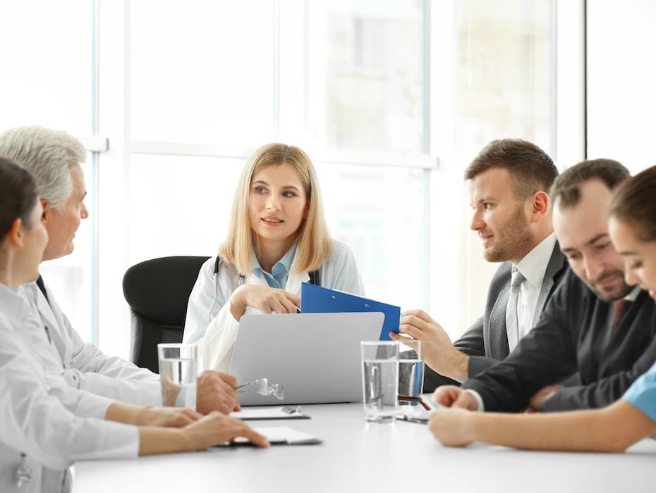 Healthcare provider and its employees sitting at a table having a discussion