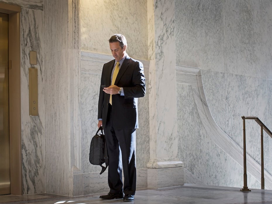 Caucasian politician using cell phone in government building