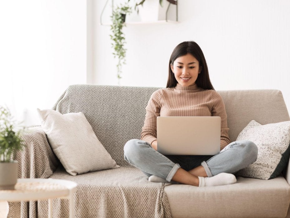 sitting on a couch with a laptop