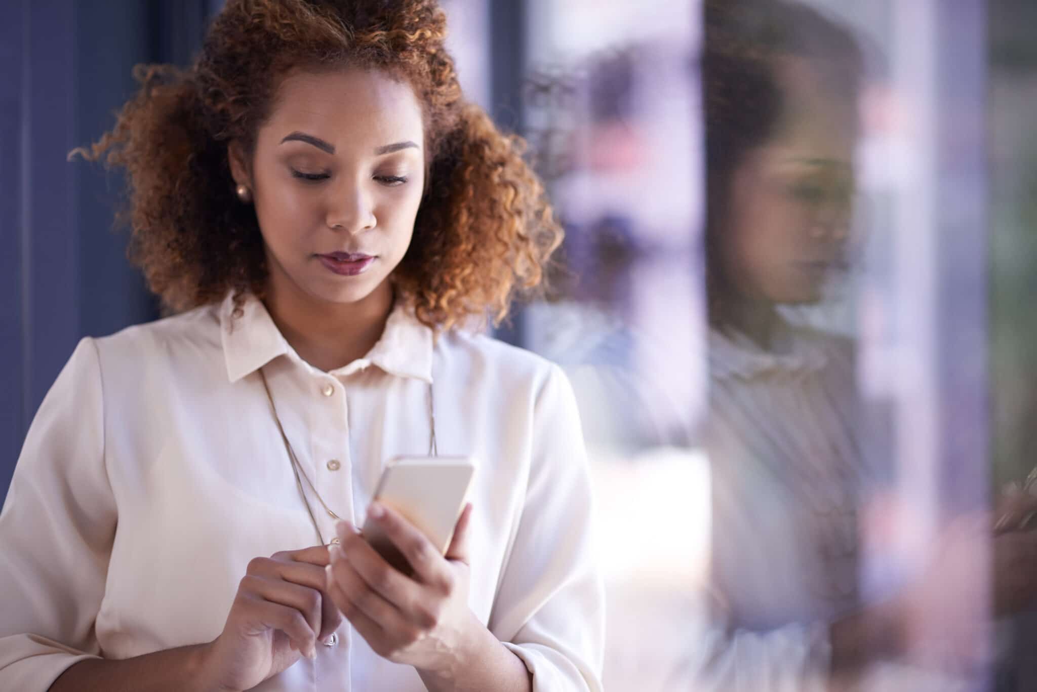 Shot of a young businesswoman using a smartphone at work