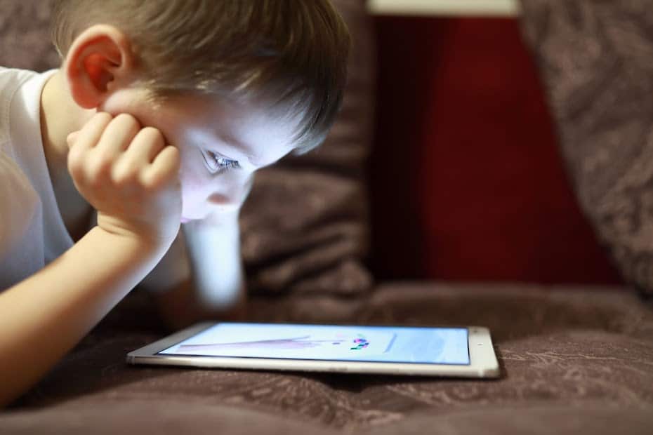 A young student reading on a tablet