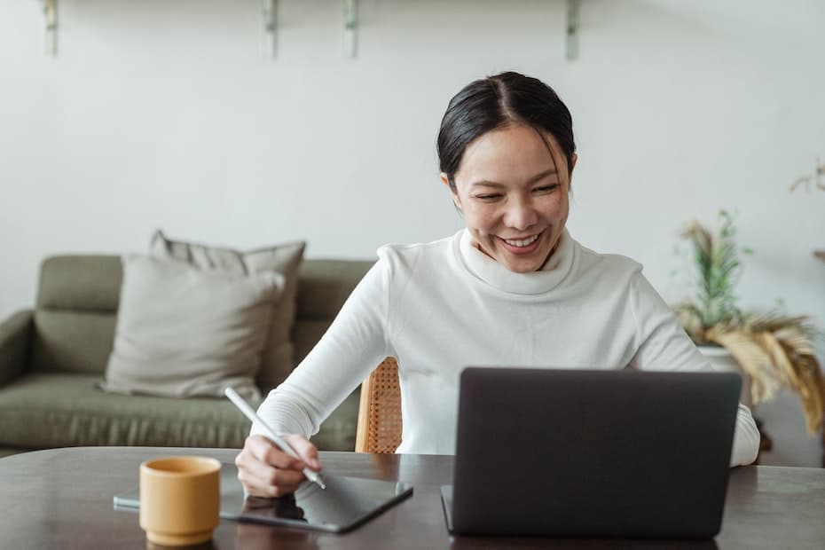 A government agency employee is happy to have internet access. Using laptop at her desk.