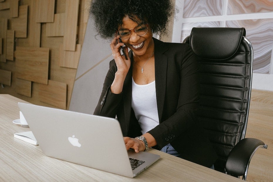 An empowered frontline rep in a retail call center helps a customer via mobile and laptop