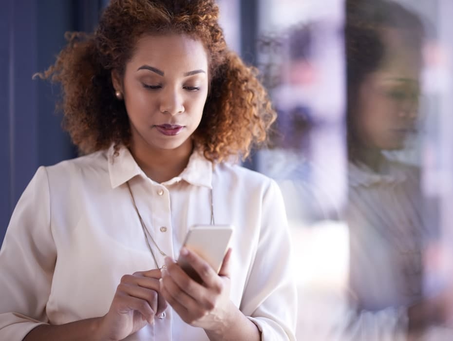 Shot of a young businesswoman using a smartphone at work