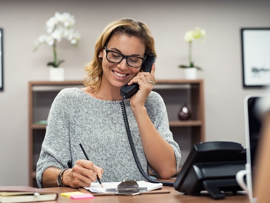 An educator sitting at her desk talking on the phone