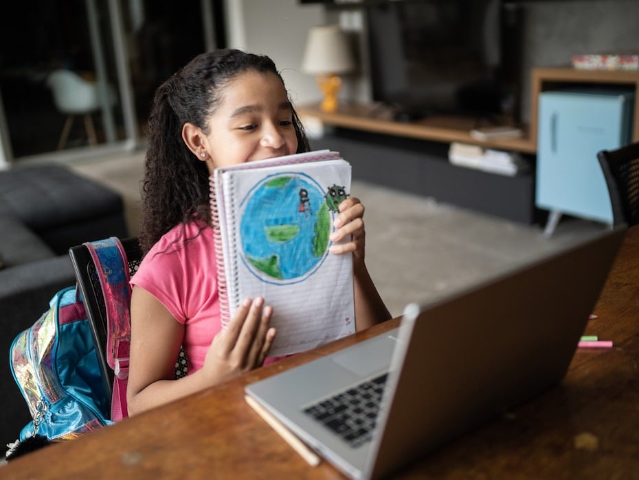 Dedicated student showing her planet earth drawing during video class at home to demonstrate the benefits of video conferencing in education