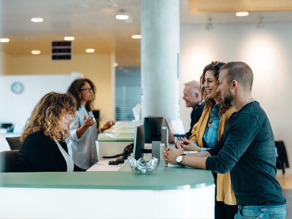 Citizens standing at the front desk of a government agency